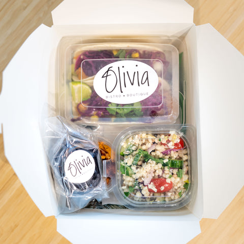 Boîte à lunch corporative d'Olivia vue du haut démontrant 2 tacos, une salade de couscous, collation de noix sucrées salées et brownies à l'avocat