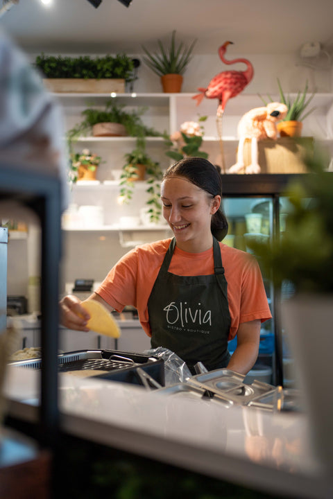 Jeune femme souriante, sur la ligne d'opération, dépose un tortillas sur le grill
